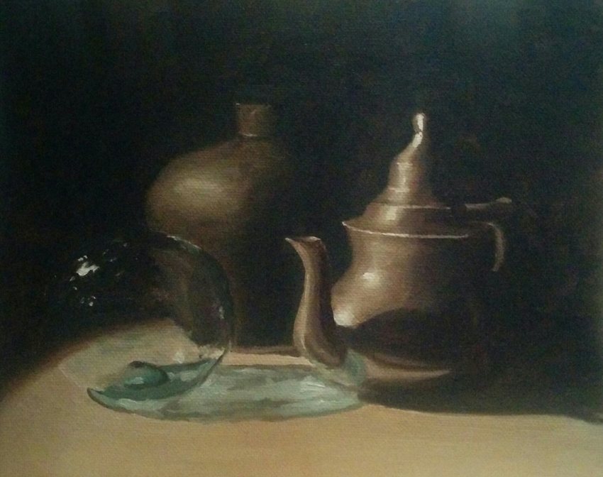 Still life of a ball, a jug and a coffee pot on a dark table.