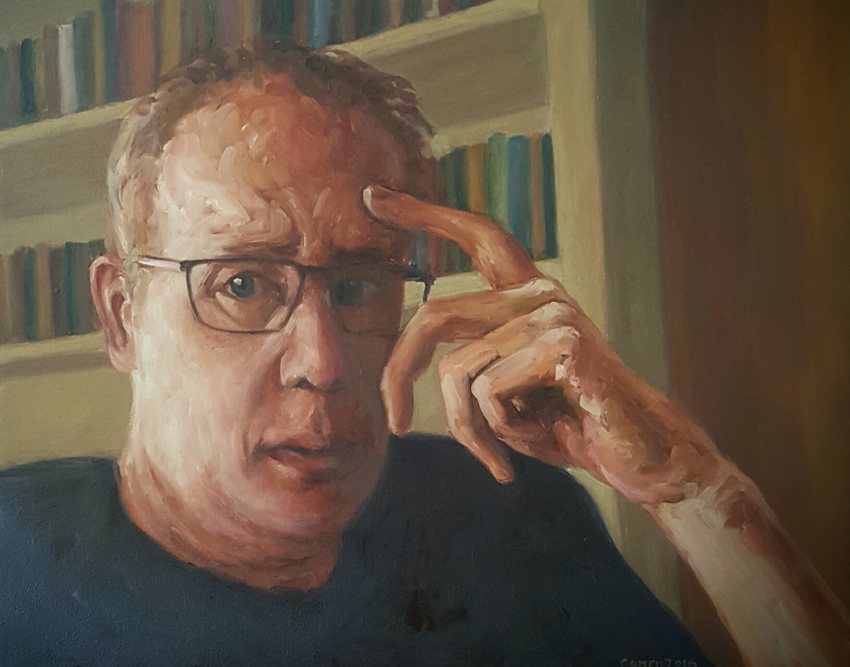 Seriously: a self-portrait of Andrew in glasses, hand to his temple, in front of bookshelves.